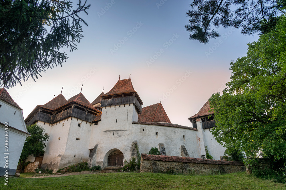 View of the fortified church of Viscri, in Transylvania (Romania), at sunset.
