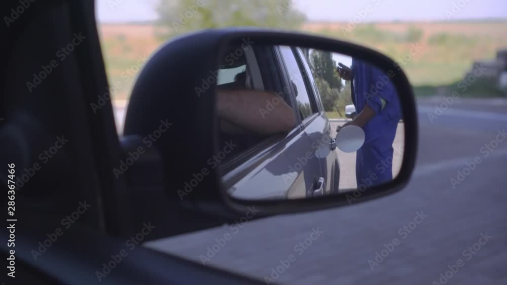 View through the side mirror of how to fill a car. filling benzine gasoline fuel in car at gas station. Refuel with nozzle machine at petrol gas pump service View through the side mirror of how to fill a car. filling benzine gasoline fuel in car at gas station. Refuel with nozzle machine at petrol gas pump service