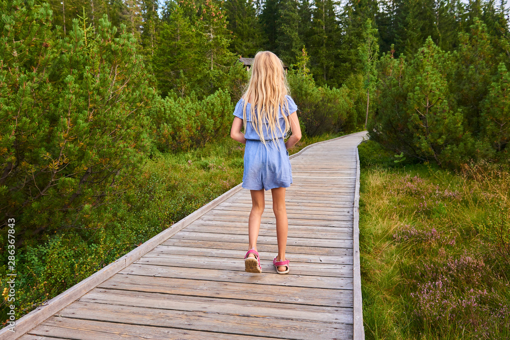 Child blond girl enjoying nature in Jezerni slat (Lake Moor) in National Park Sumava (Bohemian Forest), Czech Republic Child blond girl enjoying nature in Jezerni slat (Lake Moor) in National Park Sumava (Bohemian Forest), Czech Republic