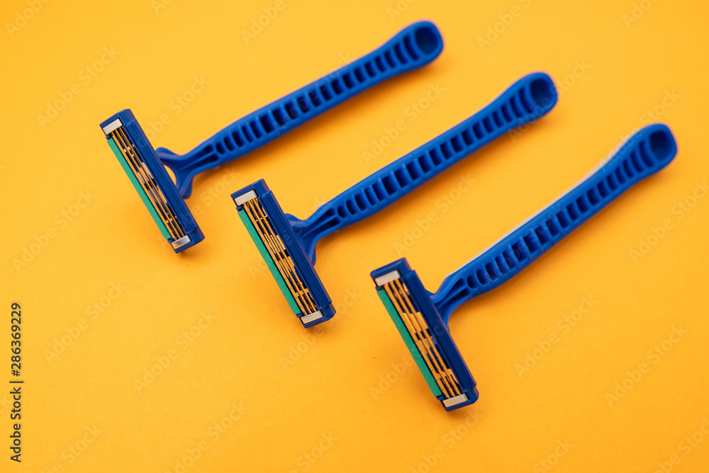 New disposable razor blade, on yellow background, isolated
