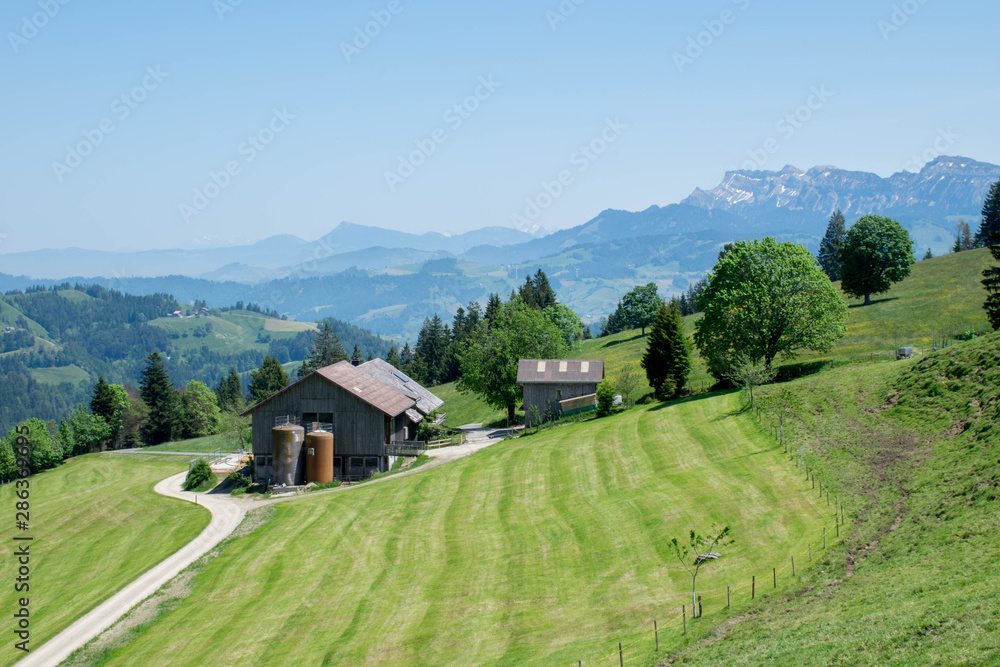 Single farming house in the Alps mountains with mountains on the background, Switzerland