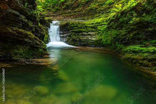 Waterfalls in green forest during a summer, exposure with a long time. The river Satina in the Beskydy Mountains, Czech Republic, Europe.