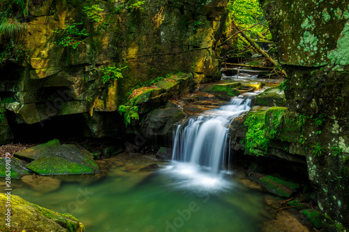Waterfalls in green forest during a summer, exposure with a long time. The river Satina in the Beskydy Mountains, Czech Republic, Europe.
