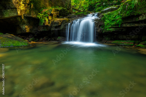 Fototapeta Naklejka Na Ścianę i Meble -  Waterfalls in green forest during a summer, exposure with a long time. The river Satina in the Beskydy Mountains, Czech Republic, Europe.