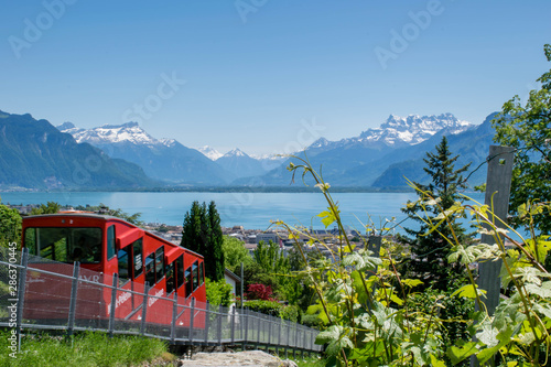 Red cable car on the top of mountain with the view on Lake Geneva and Alps mountains