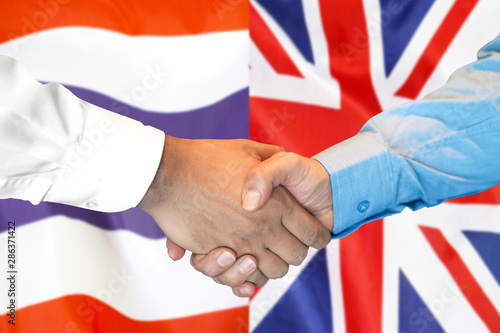 Business handshake on the background of two flags. Men handshake on the background of the Thailand and United Kingdom flag. Support concept