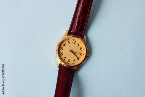 Gold and quartz watch on a blue background.