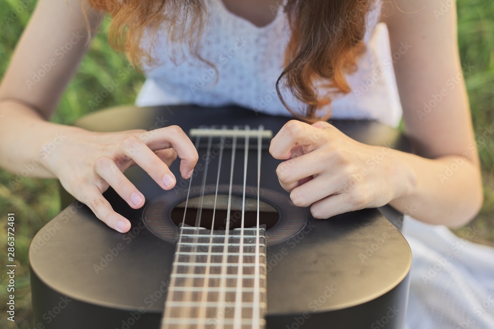 Fototapeta premium Close-up hands fingers of girl playing guitar