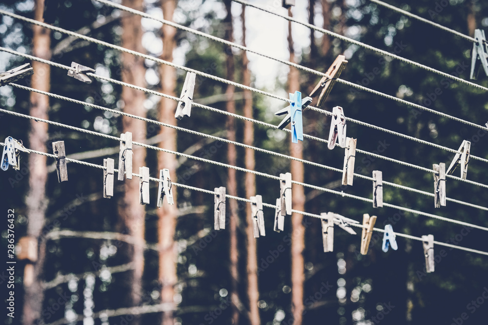 Outdoor clothes dryer with clothespins on a blurred background of pines