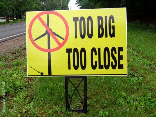 A sign suggesting that electric power windmills are too big and too close to homes.