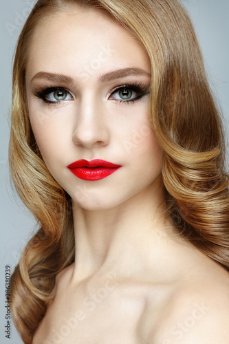 Young beautiful woman with prom hairdo and red lipstick