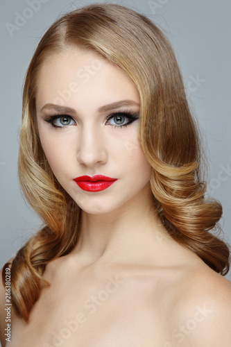 Young beautiful woman with prom hairdo and red lipstick