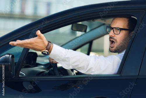 Angry businessman yelling out car window © Goran