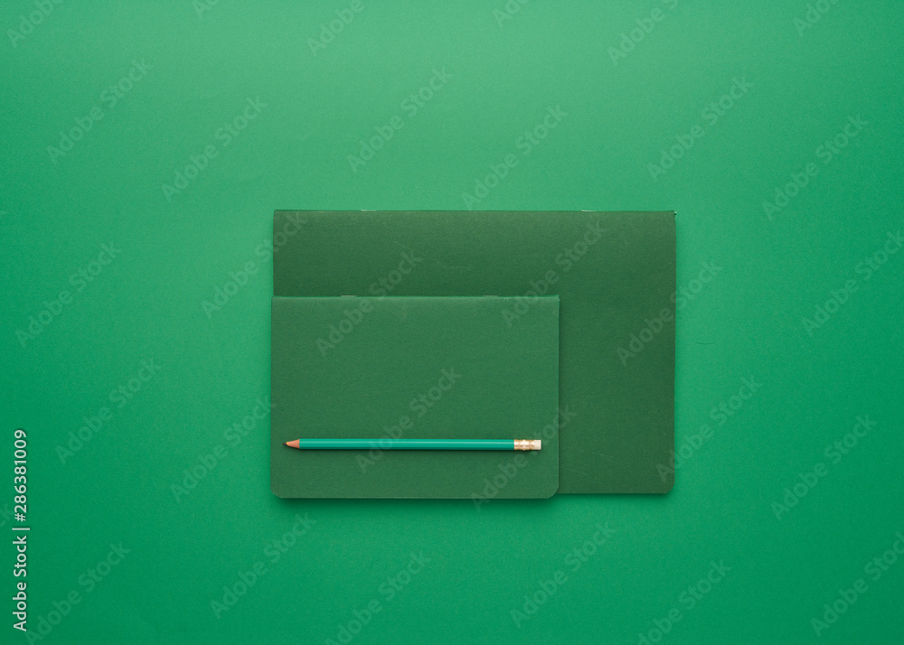 notebook on a green background, back to school, student accessories, free space for an inscription, lay flat notebook on a green background, back to school, student accessories, free space for an inscription, lay flat