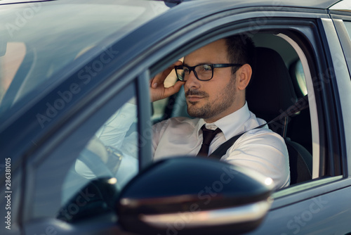 Close up of a businessman driving a car © Goran