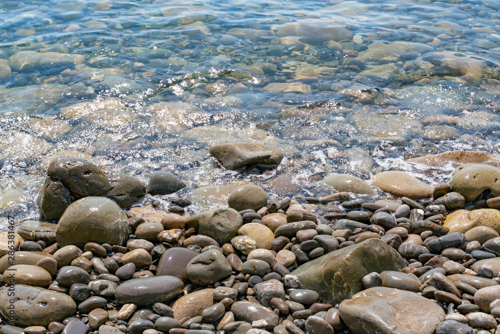 Transparent water splashing on the stones on the shore