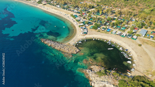 Aerial drone view of iconic sandy turquoise organised with sun beds and umbrellas beach of Paliouri in Kassandra Peninsula, Halkidiki, North Greece photo