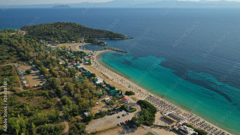 Aerial drone view of iconic sandy turquoise organised with sun beds and umbrellas beach of Paliouri in Kassandra Peninsula, Halkidiki, North Greece