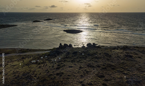 Foto Scenic drone view of Caye Chateau from the hills at sunset with sheep and goats