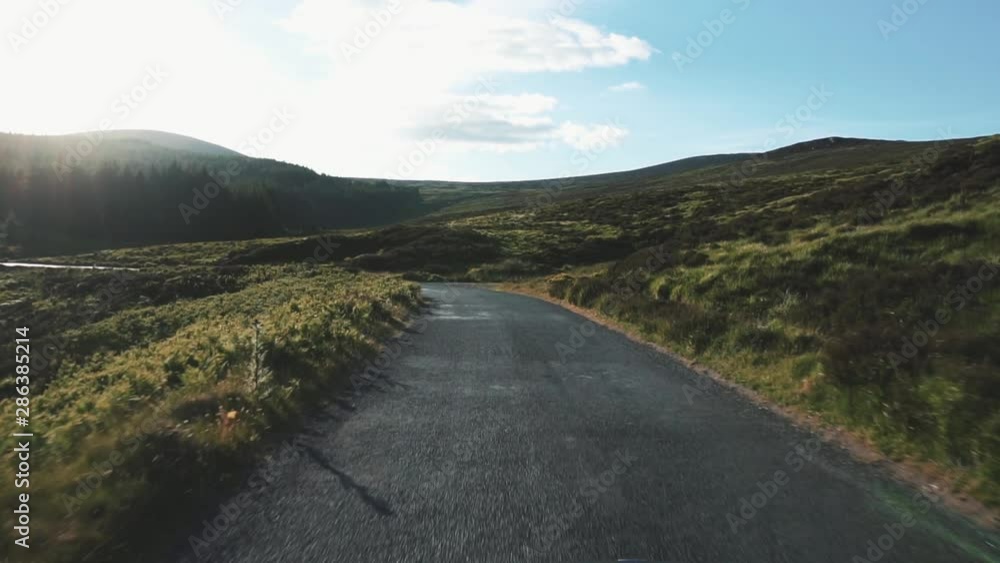 FPV: Driving in the road to Cooley Mountains with a blue sky and clouds as background. FPV: Driving in the road to Cooley Mountains with a blue sky and clouds as background.