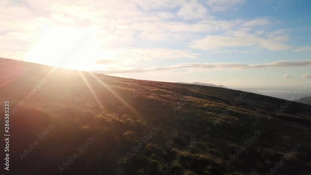 Aerial view of Cooley Mountains, drone flying forward with sun in front and flare. Aerial view of Cooley Mountains, drone flying forward with sun in front and flare.