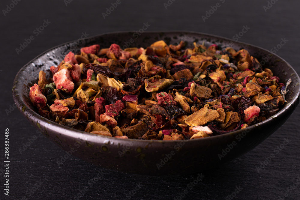 Lot of pieces of lavender strawberry ice tea on grey ceramic plate on grey stone Lot of pieces of lavender strawberry ice tea on grey ceramic plate on grey stone
