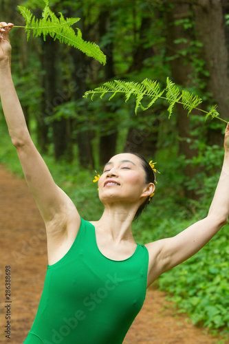 Woman in green dress, dancing in the Connecticut woods.