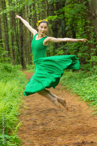 Woman in green dress, dancing in the Connecticut woods.
