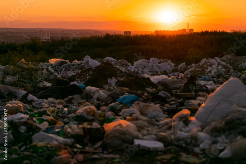 A beautiful sunset ruined by a pile of trash left in the middle of a meadow.