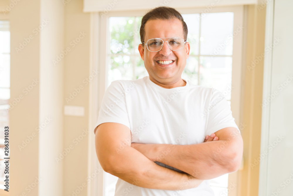 Middle age man wearing glasses smiling to the camera at home Middle age man wearing glasses smiling to the camera at home