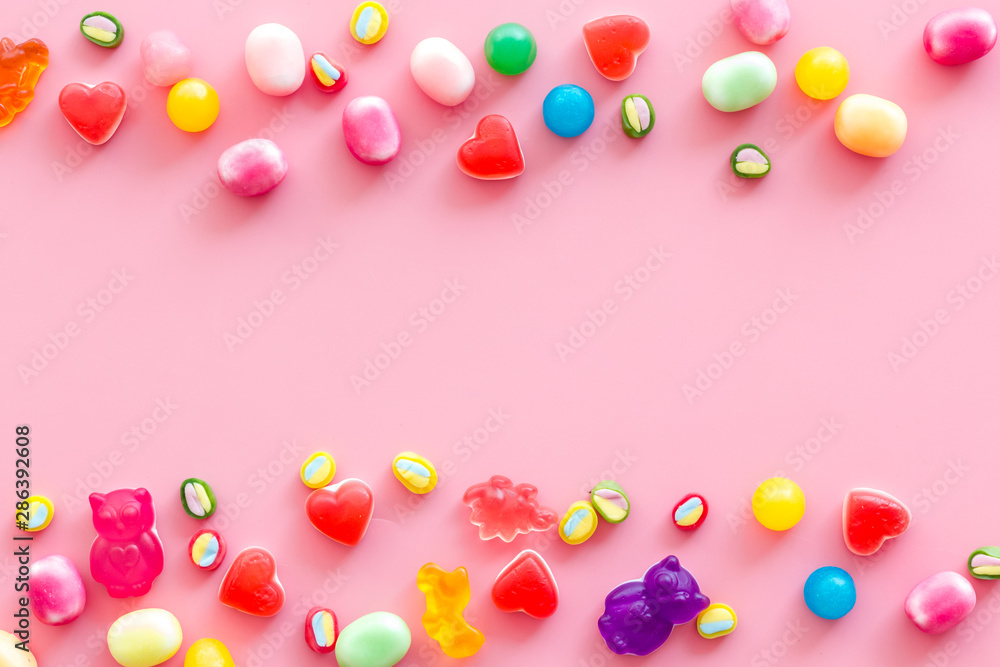 Assorted sweets and marmalade frame on pink background top view space for text Assorted sweets and marmalade frame on pink background top view space for text