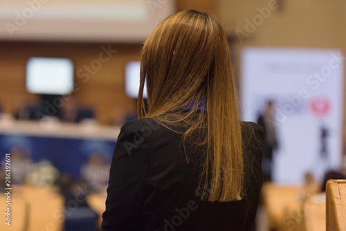 Business woman representing model of economic development and startup business, woman as a leader. Audience at the conference hall, Business Conference and Presentation.