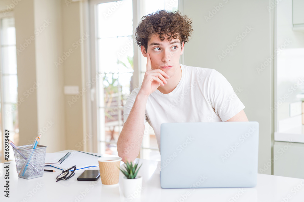 Young student man working and studying using computer laptop serious face thinking about question, very confused idea Young student man working and studying using computer laptop serious face thinking about question, very confused idea