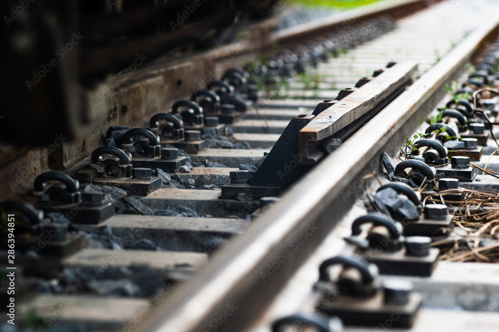 Close up Steel railroad fasteners.Iron nuts fastened to railway tracks.soft focus. Close up Steel railroad fasteners.Iron nuts fastened to railway tracks.soft focus.