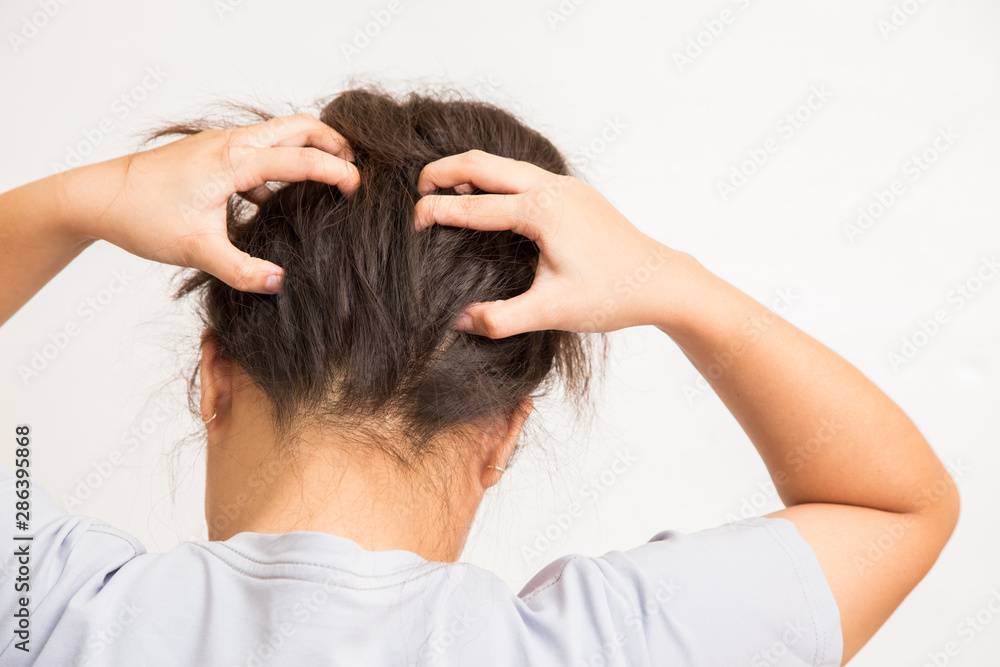 Woman suffering from an headache itching her head Woman suffering from an headache itching her head