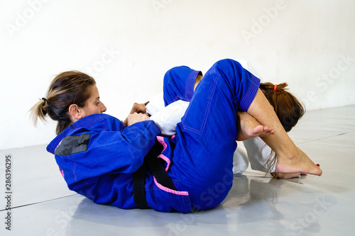 фотографія Omoplata submission judo bjj brazilian jiu jitsu training sparring two women fem