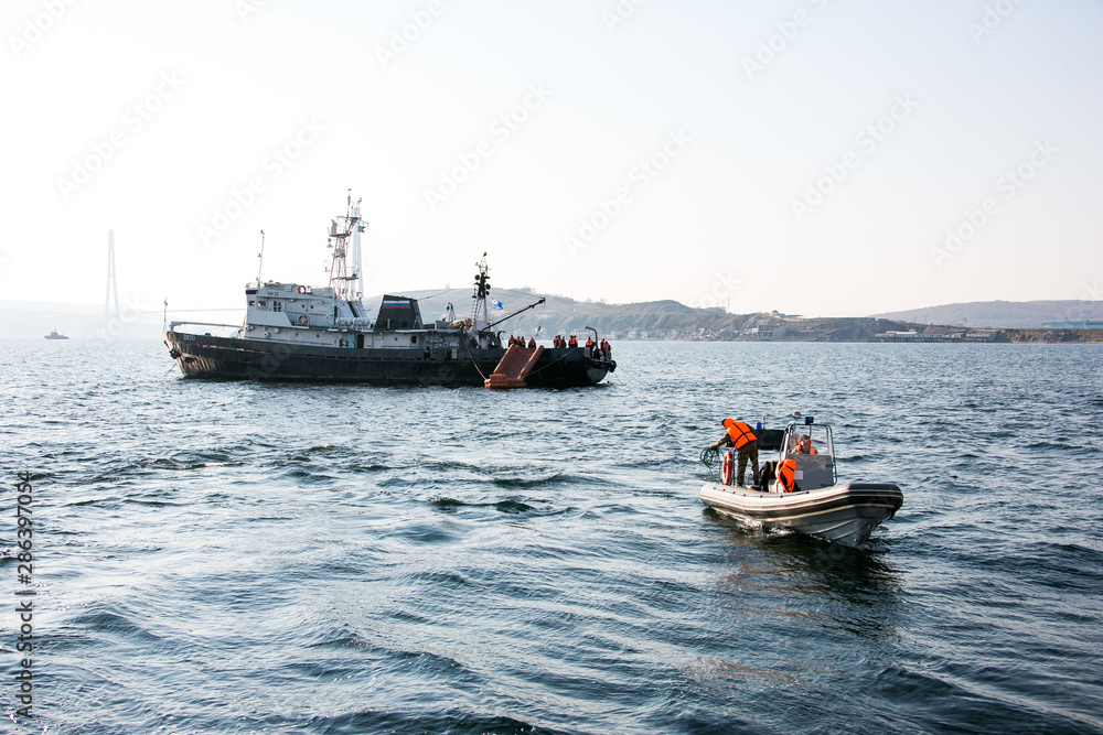 Rescue marine vessel during a rescue operation at sea. A motor boat with lifeguards moves by sea.