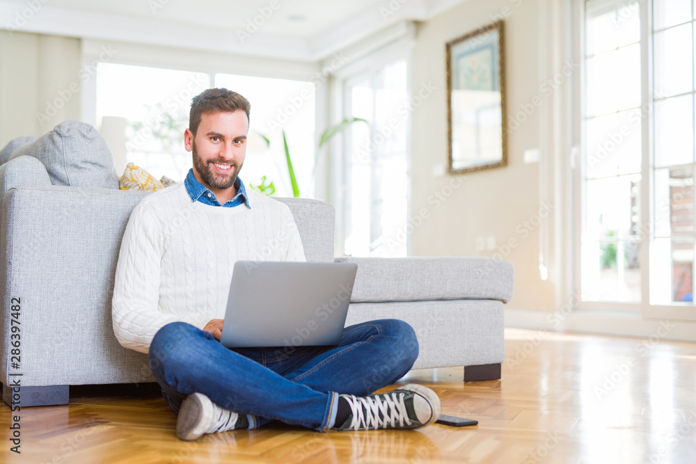 Handsome man wearing working using computer laptop with a happy face standing and smiling with a confident smile showing teeth Handsome man wearing working using computer laptop with a happy face standing and smiling with a confident smile showing teeth