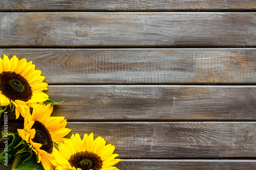 Fototapeta Naklejka Na Ścianę i Meble -  Beautiful yellow sunflowers frame on wooden background top view mock-up