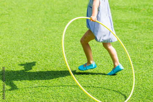 Little girl running with hula hoop