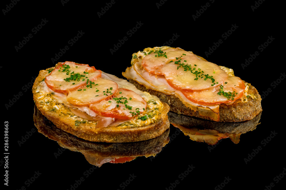 Croque-monsieur on black glass with reflection
