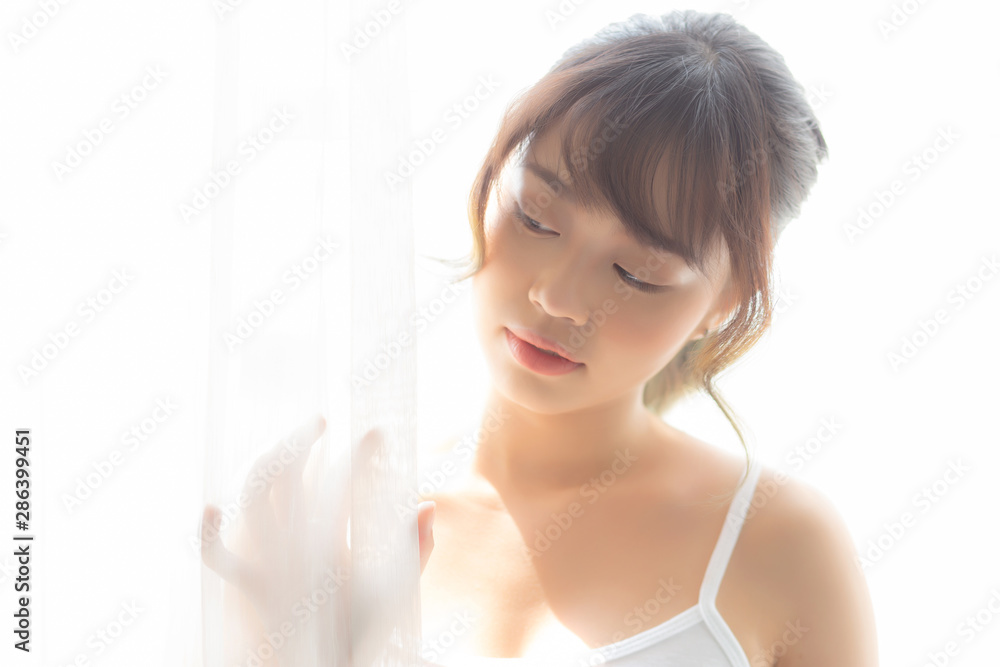 Portrait of beautiful young asian woman standing the window and smile while wake up with sunrise at morning, girl happy with freshness and cheerful, lifestyle and relax concept. Portrait of beautiful young asian woman standing the window and smile while wake up with sunrise at morning, girl happy with freshness and cheerful, lifestyle and relax concept.