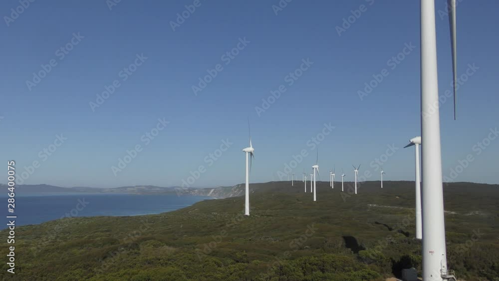 Wind farm at coast of Western Australia, generating clean renewable energy, with blue sky and horizon as background. Wind farm at coast of Western Australia, generating clean renewable energy, with blue sky and horizon as background.