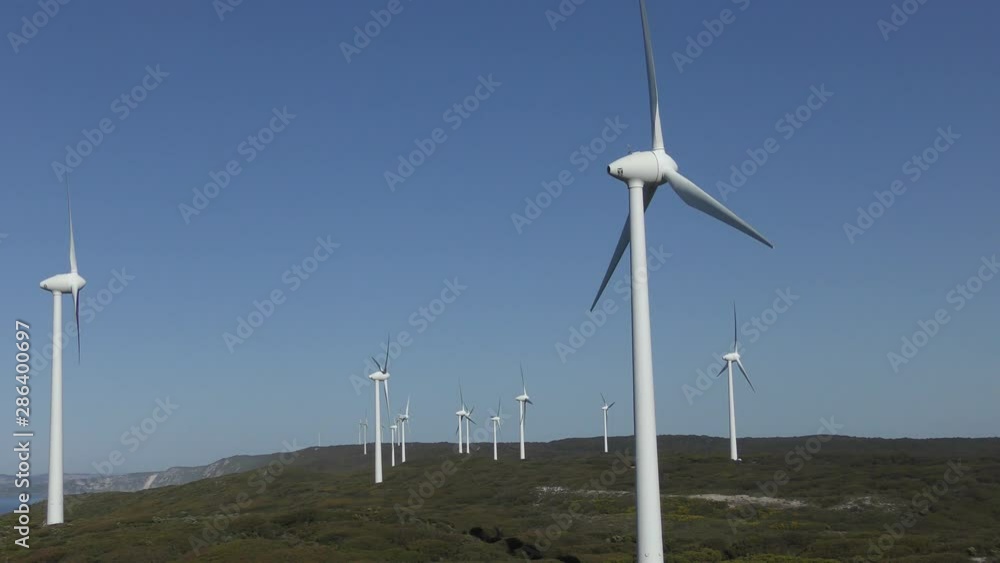 Wind farm at coast of Western Australia, generating clean renewable energy, with blue sky and horizon as background. Wind farm at coast of Western Australia, generating clean renewable energy, with blue sky and horizon as background.