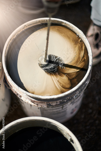 Bucket with mixing paint for wall, diy concept.