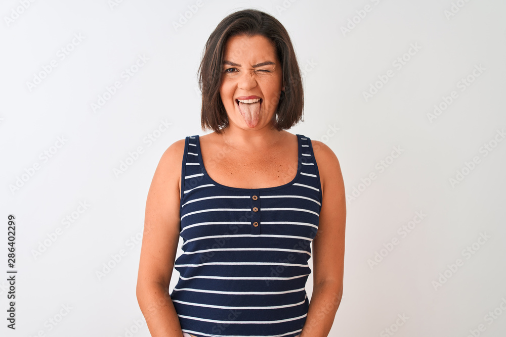 Young beautiful woman wearing blue striped t-shirt standing over isolated white background sticking tongue out happy with funny expression. Emotion concept. Young beautiful woman wearing blue striped t-shirt standing over isolated white background sticking tongue out happy with funny expression. Emotion concept.