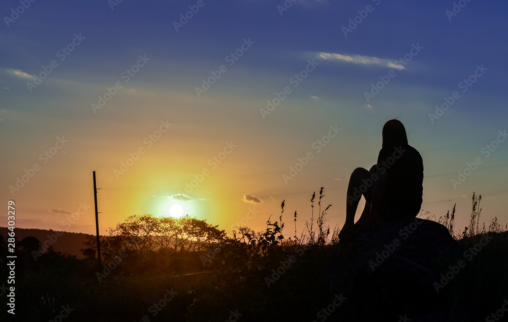 Girl contemplating the sunset.