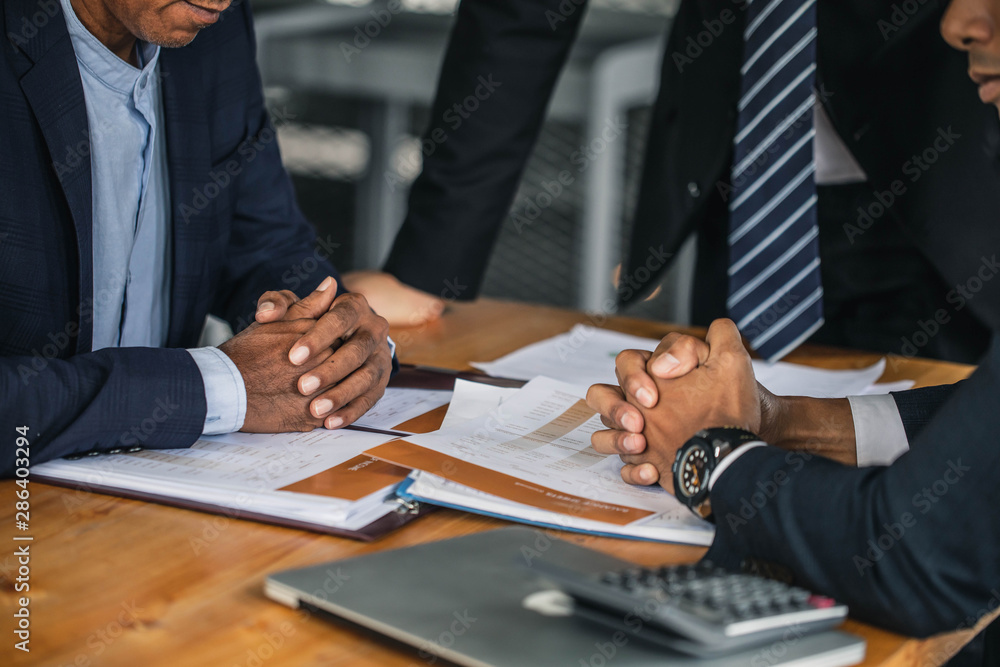 Negotiation of two statesman with clasped hands in office. Two men's hand on a desk. Negotiating business concept. Negotiation of two statesman with clasped hands in office. Two men's hand on a desk. Negotiating business concept.
