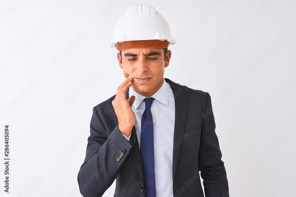 Young handsome architect man wearing suit and helmet over isolated white background touching mouth with hand with painful expression because of toothache or dental illness on teeth. Dentist concept. Young handsome architect man wearing suit and helmet over isolated white background touching mouth with hand with painful expression because of toothache or dental illness on teeth. Dentist concept.