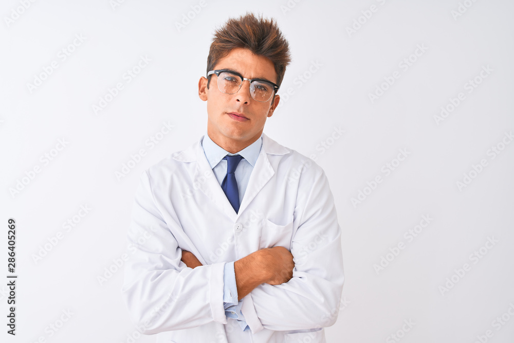 Young handsome sciencist man wearing glasses and coat over isolated white background skeptic and nervous, disapproving expression on face with crossed arms. Negative person. Young handsome sciencist man wearing glasses and coat over isolated white background skeptic and nervous, disapproving expression on face with crossed arms. Negative person.